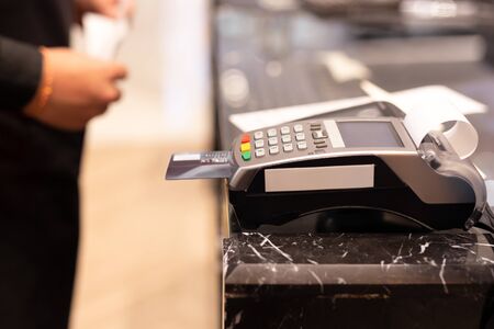 Cashier using credit card machine for customer shopping payment in store.の写真素材