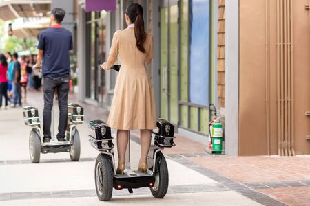 Couple in riding modern gyro scooter hover board at shopping mall.の写真素材