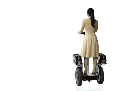 Rear view of woman in uniform riding a hoverboard isolated in clipping path.の写真素材