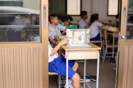 Unidentified children study in the classroom with open book.の写真素材