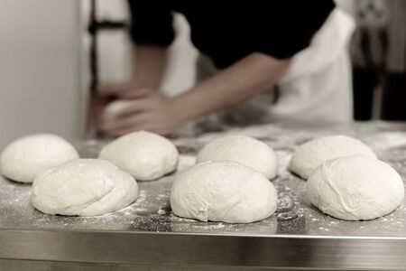ball of pizza dough on cooking table with chefの写真素材