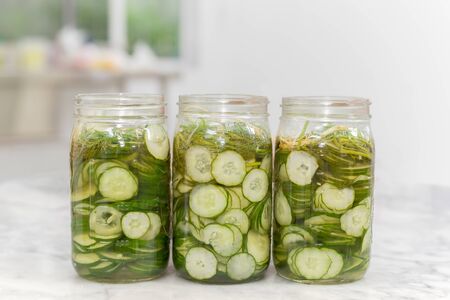 Homemade slice cucumbers pickle in a Jar on marble table.の写真素材