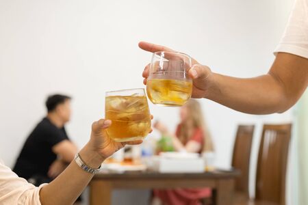 Friends toasting glass of whiskey celebration in restaurant
