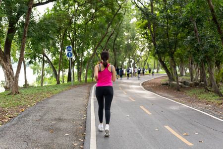 Fitness sportswoman exercise running on park trail in the morning.の写真素材