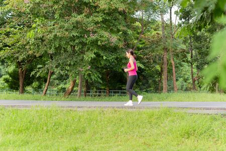Fitness sport woman running on the path trail in the park in morning.の写真素材