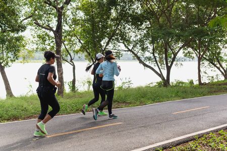 Group of woman exercise running on park trail in the morning.の写真素材