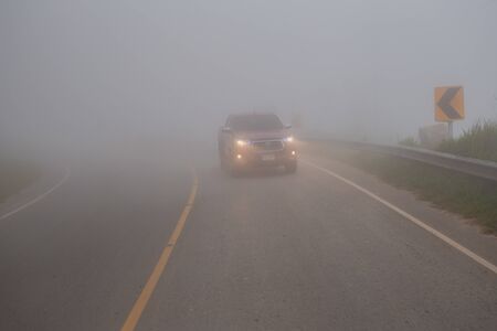 Phu Tub Berk, Phetchabun Thailand 28 Sep 2019 - Toyota truck driving in the fog mountain with headlight beams in dense mist.のeditorial素材