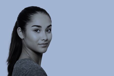 Beauty young mixed race woman face isolated in blueの写真素材