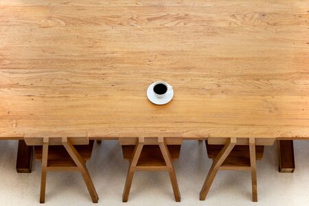Top view cup of coffee on wooden table with wooden chair in cafe.の写真素材