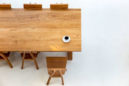 Top view cup of coffee on wooden table with wooden chair in cafe.の写真素材