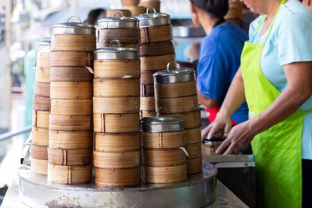 Bamboo steamer sits on top of water steam at restaurant.の写真素材
