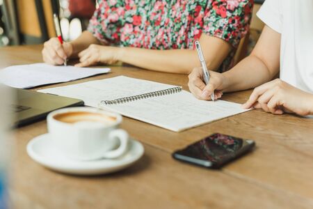 Business woman hands writing on notebook documents.