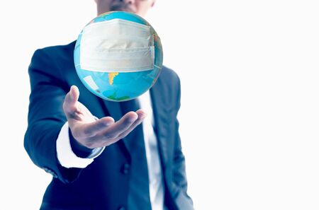 Human hand holding world globe with face mask Concept worldwide for COVID 19.の写真素材