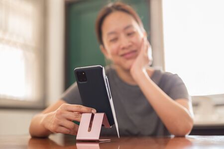 Social distancing happy smiling woman using cell phone video call family.