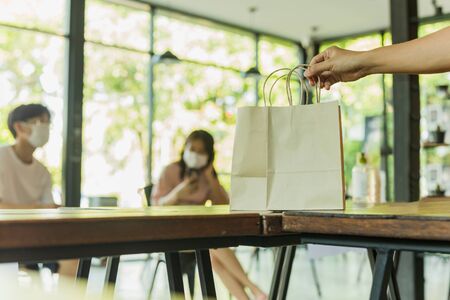 Waiter serving takeaway food to customer social distance conceptual.の写真素材
