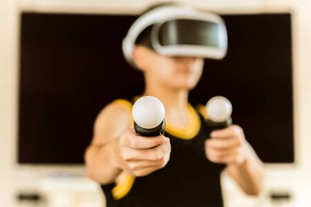 Teenager boy playing game with Virtual reality headset with goggles.