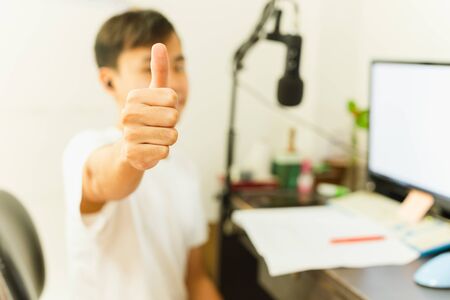 Asian boy study at home using pc and showing thumps up.の写真素材