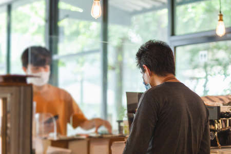 New nomarl waiter service customer at cafe counter with partition.の写真素材