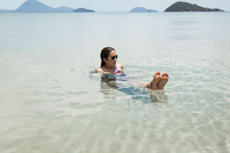 Woman bathing in the sea on summer vacation in tropical island.