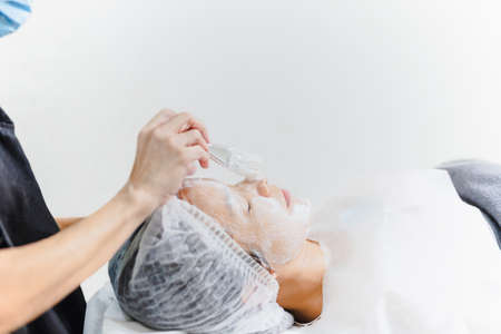 Beauty treatment skin care woman getting facial care by beautician at spa salon.の写真素材