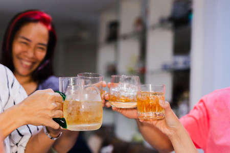 Group of friends toasting glasses whisky in the party at family dinner.の写真素材