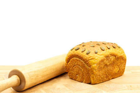 Homamade whole wheat bread loaf with pumkin seeds in white background.