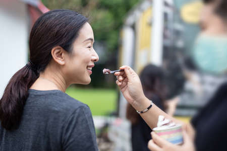 Lesbian couple gives her partner a taste of ice cream.