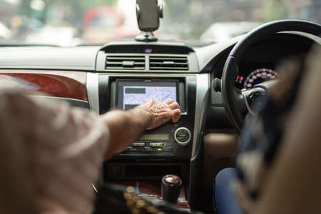 Father hand using car system control on touch screen while daughter driving.の写真素材