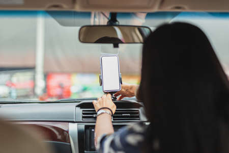 Woman driver hand adjust cell phone for direction.の写真素材