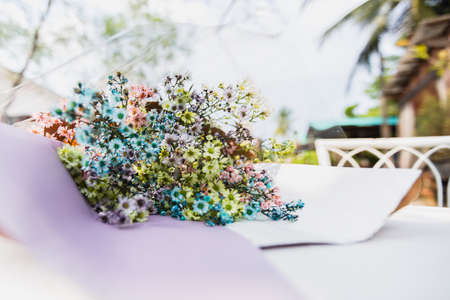 Bouquet of dried multicolor flowers lying on table.
