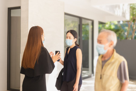 Daughter with senior father wearing face mask looking for new home with real estate.の写真素材