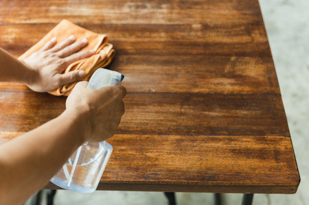 Waiter cleaning table with disinfectant spray for protect infection covid-19 in cafe.の写真素材