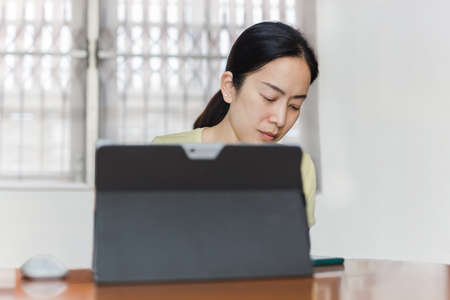 Beautiful casual woman looking smartphone while work with laptop.の写真素材