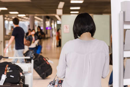 Woman toruist at the airport with tluggage waiting for departure.の写真素材