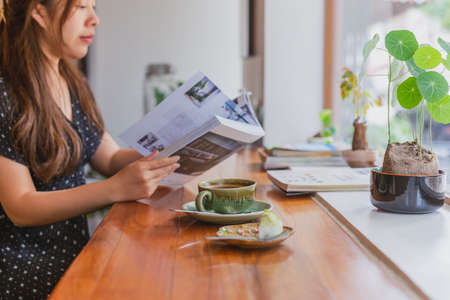 Female reading a magazine and drink coffee in cafe.の写真素材