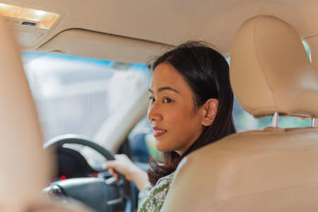 Woman looking over her shoulder while driving a car.