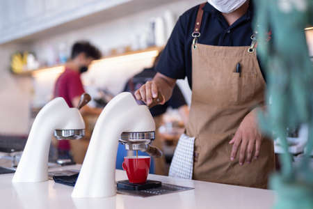 Flair espresso machine in a coffee shop with barista.