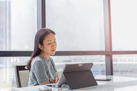 Woman working on laptop sitting at home during Covid-19 quarantine.の写真素材