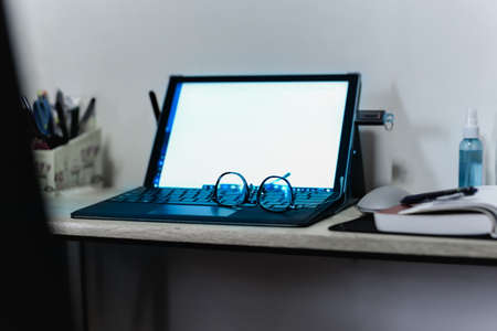 Eyeglass on laptop keyboard and alcohol spray on table.の写真素材