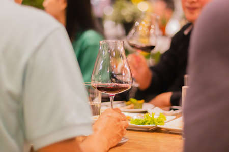 Selected focus of glasses of red wine on table at meeting dinner in indoor.