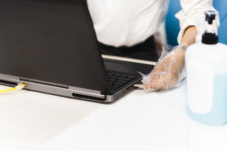 Hygiene health care concept Man hand with gloves insert USB flash drive into a laptop.の写真素材