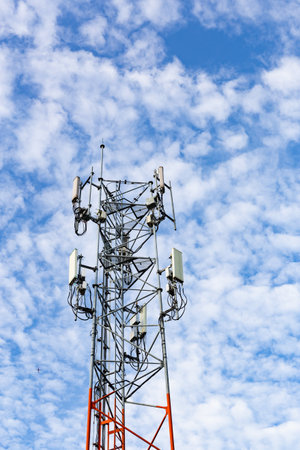 Vetical of telecommunication tower with blue sky and white clouds background.