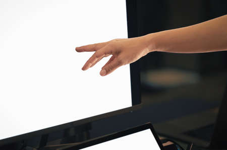 Woman working on computer with hand pointing at desktop screen.の写真素材