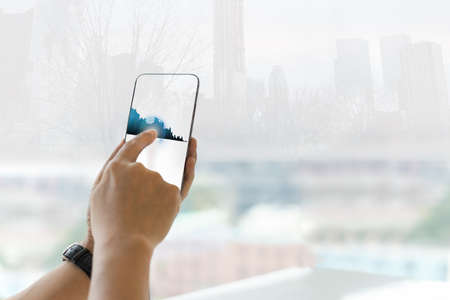 Double exposure business man using cell phone with buildings technology and growing market.