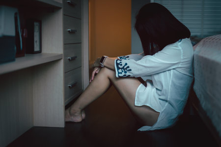 depressed woman sitting on floor in bedroom at home.の写真素材