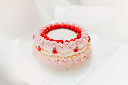 Pink and white birthday cake with decoration.