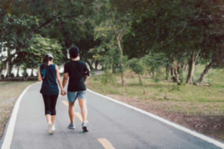 Blurred concept of couple in lover holding hands exercise walking in the park.の写真素材