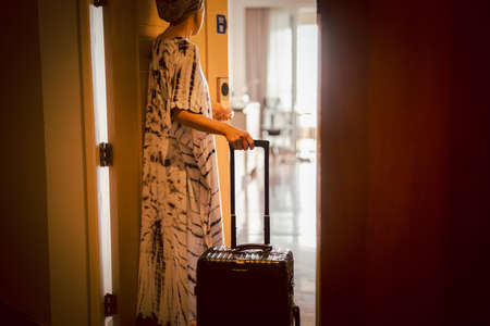 Tourist woman open the door of hotel room, Vacation conceptual.の写真素材
