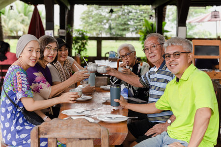 Group of happy family having lunch and making a toasting at restaurant.の写真素材