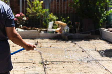Worker watering sand to make cement floor.の写真素材